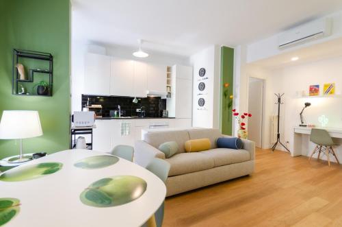 a living room with a couch and a table at Vivimi Home Fiordalisi Stile & Comfort Vicino Metro in Milan