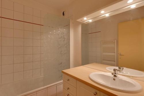 une salle de bain blanche avec un lavabo et une douche dans l'établissement Cabourg - 19 - Studio proche pistes - 4 pers, à Les Deux Alpes