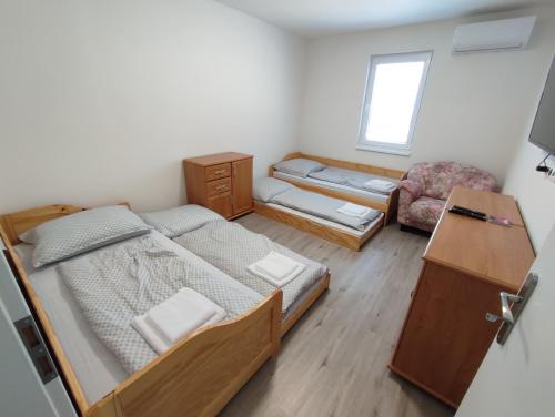 a small room with two bunk beds and a chair at BÖJTÖS apartmány NESVADY in Nesvady