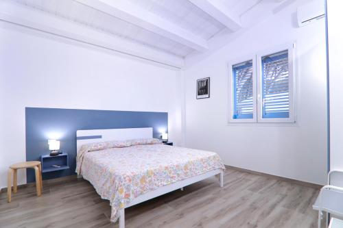 Resort Giglio di Mare في سيليا مارينا: غرفة نوم بيضاء بها سرير ونافذة