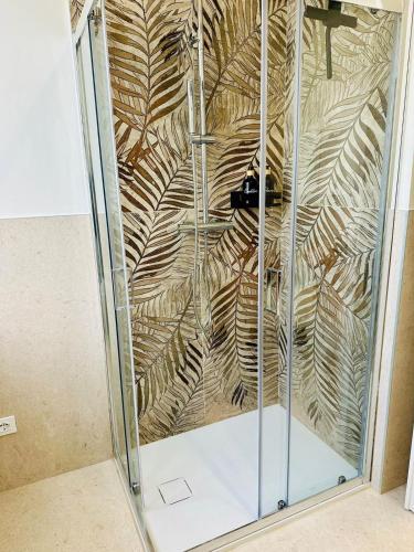 a glass shower with a design of leaves at D-Living Casa Vigevano in Vigevano