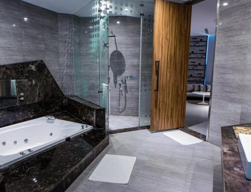 bagno con vasca e doccia in vetro di All-Ur Boutique Motel - Tai Tung Branch a Città di Taitung