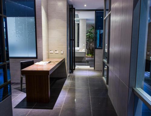 a room with a wooden desk and a bathroom at All-Ur Boutique Motel - Tai Tung Branch in Taitung City