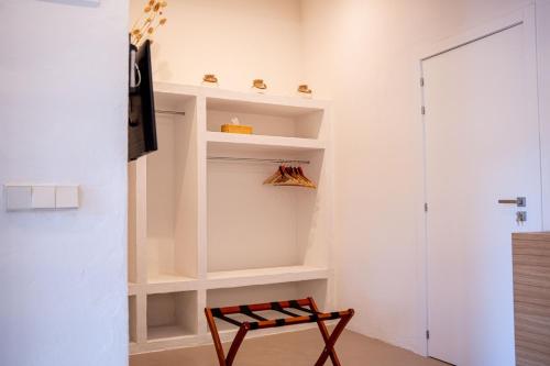 a walk in closet with a bench in a room at Hotel Monells Summum in Monells