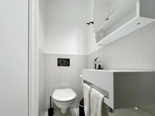 une salle de bain blanche avec des toilettes et un lavabo dans l'établissement Tivoli 3 - Renovated 2 bedrooms appartment, Nice terrace, Monaco Border, 5mn from Casino Monte Carlo, à Beausoleil