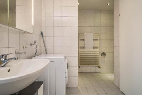 a white bathroom with a sink and a shower at Cocoon am Schloß Top 2 in Lochau