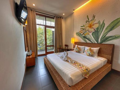 a bedroom with a large bed with a tv on the wall at Hostel by Monsoon Riverside in Phnom Penh