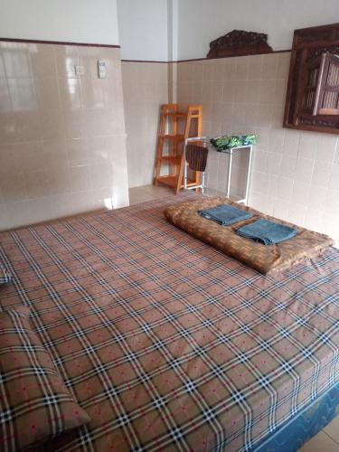 uma cama grande num quarto com um cobertor em Cempaka 2 Homestay em Legian