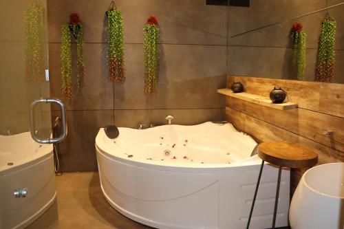een bad in een badkamer met planten aan de muur bij HOTEL WELCOME in Surat