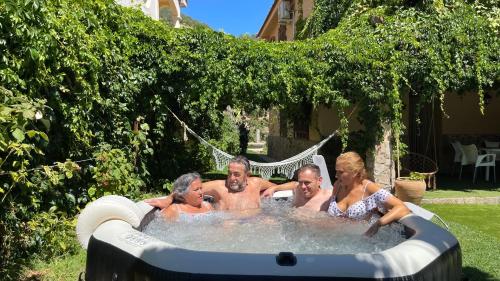 a group of people in a jacuzzi in a backyard at Villa del Jerte in El Torno