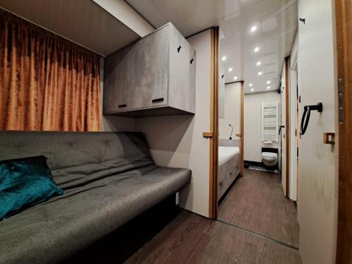 a small bedroom with a bed and a bathroom at Hausboot Tegel in Zeuthen
