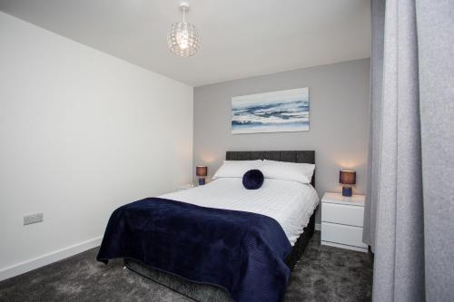 a white bedroom with a bed and a chandelier at Potterhouse Durham by #ShortStaysAway in Sheepscar