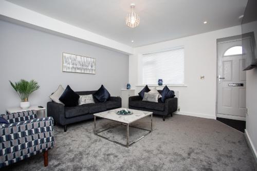 a living room with two couches and a table at Potterhouse Durham DH1 in Sheepscar