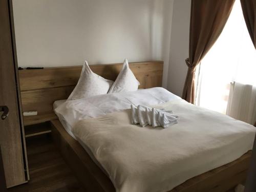 1 cama con sábanas y almohadas blancas y ventana en Cabana Pojorata, en Pojorîta