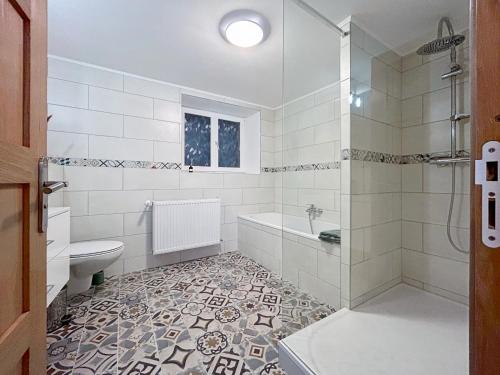a bathroom with a tub and a toilet and a sink at Epfig Maison in Epfig