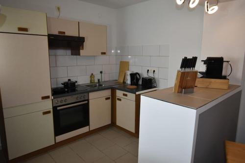 a small kitchen with a stove and a refrigerator at Ferienwohnung mit Boxspringbett in Behrensdorf