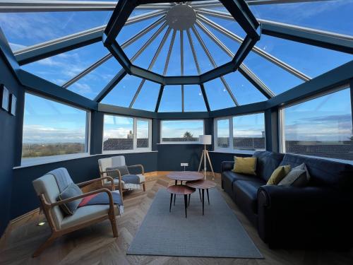 a living room with a large glass ceiling at Hunters Glebe Country Apartment in Castlerock