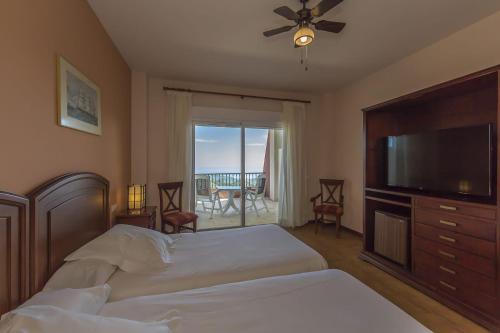 a bedroom with a bed and a flat screen tv at Hotel Wellness Marbella Hills in Ojén