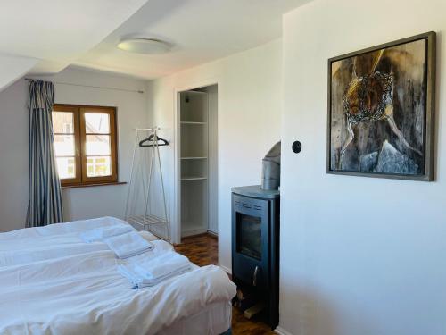 a bedroom with a bed and a painting on the wall at Lütt Oven Hus in Hiddensee