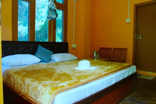a bedroom with a bed with a hat on it at Corridor Homestay in Sainj