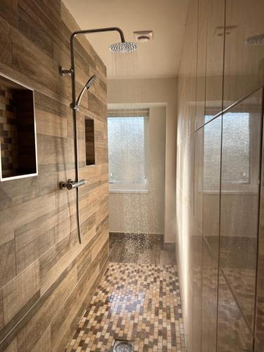a shower with a glass door in a bathroom at Hunters Glebe Country Apartment in Castlerock