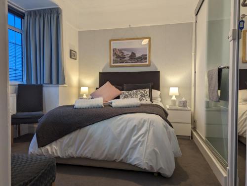 a bedroom with a large bed and a chair at Cliftonville, en-suite room, fridge microwave TV, great value homestay near the sea in Lymington