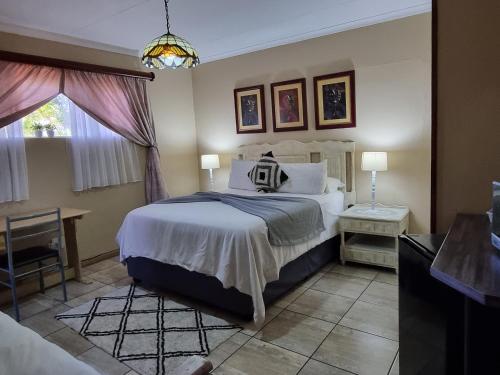 a bedroom with a large bed and a window at African Sky Guest House in Krugersdorp