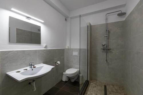 a bathroom with a sink and a toilet and a shower at Sky Rooms by Volo Guest House in Sub Coastă