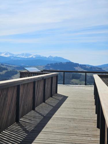 a wooden boardwalk with mountains in the background at Domek z jacuzzi Tatrzańskie Serce in Czerwienne