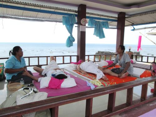 a group of people laying on beds on the beach at Lanta New Beach Bungalows - SHA Plus in Ko Lanta
