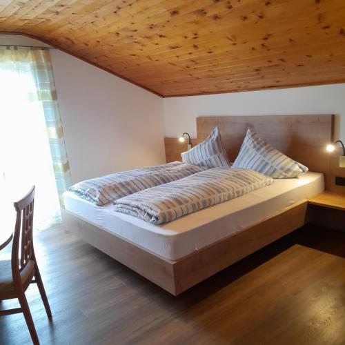 a bedroom with a large bed with a wooden ceiling at Haus Evi in Termeno