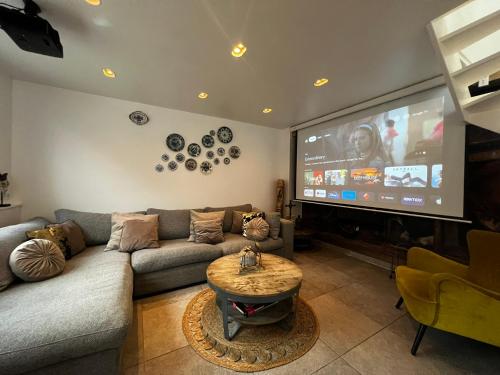 een woonkamer met een bank en een flatscreen-tv bij Luxury apartment in farmhouse near Amsterdam in Ilpendam
