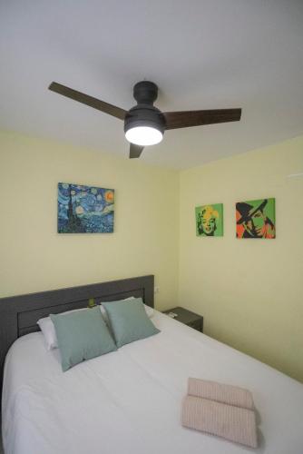 a bedroom with a white bed with a ceiling fan at Apartamento Casa Esther y Xavi in Vilafamés