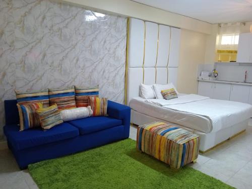 - une chambre avec un lit et un canapé bleu dans l'établissement Airport Studio Apartments-JKIA, à Nairobi