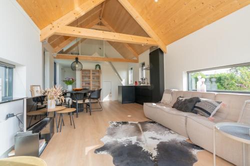a living room with a couch and a table at Riethoek Westerschouwen in Burgh Haamstede