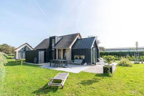 a black house with a black roof at Riethoek Westerschouwen in Burgh Haamstede