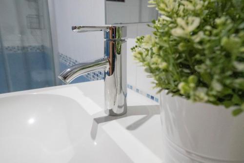 a bathroom sink with a faucet and a plant at Apartamento-Loft con vistas in Vilafamés