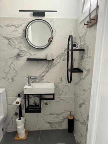埃爾莫波利斯的住宿－BYZANTIUM APARTMENTS，浴室设有水槽和墙上的镜子