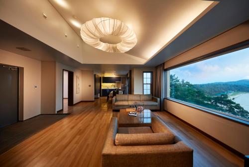 a living room with a couch and a large window at Eldorado Resort in Sinan