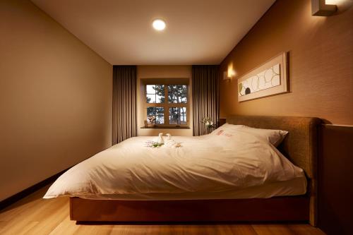 a bedroom with a large white bed with a window at Eldorado Resort in Sinan