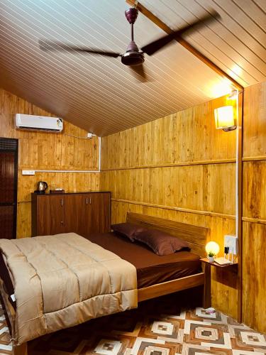 um quarto com uma cama numa parede de madeira em Stay In Woods em Bogmalo