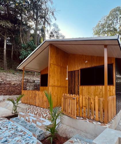 uma casa de madeira com uma cerca em frente em Stay In Woods em Bogmalo