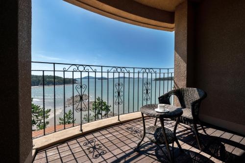a balcony with a table and chairs and a view of the ocean at Eldorado Resort in Sinan