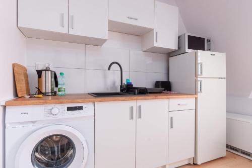 a white kitchen with a washer and dryer at Groszowa Comfort Studio in Jelenia Góra