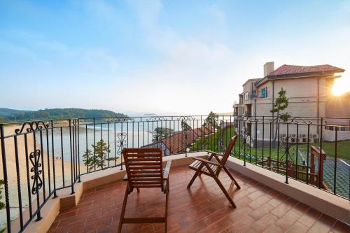 a balcony with two chairs and a view of the water at Eldorado Resort in Sinan