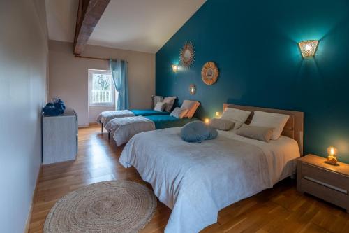 ein Schlafzimmer mit 2 Betten und einer blauen Wand in der Unterkunft Les pierres de Fonfage in Boissezon