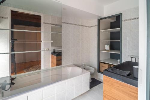 ein weißes Badezimmer mit einer Badewanne und einem Waschbecken in der Unterkunft Les pierres de Fonfage in Boissezon