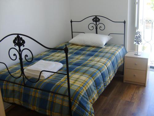 - une chambre dotée d'un lit avec une couverture bleue et jaune dans l'établissement Maison Garrett, à Portalegre