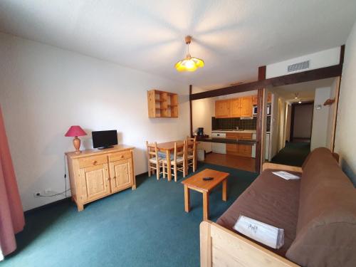 un petit salon avec un canapé et une cuisine dans l'établissement Cabourg - 22 - Studio spacieux - 4 pers, à Les Deux Alpes