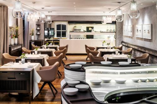 a restaurant with tables and chairs and a bar at Söl'ring Hof in Rantum